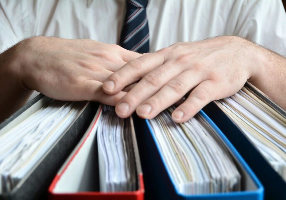 A person in a tie is holding some papers